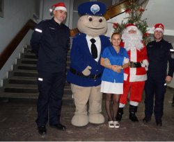 Święty Mikołaj, sierż. Pyrek pozują do wspólnego zdjęcia z policjantami oraz personelem szpitala.